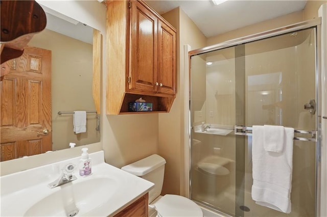 full bath featuring toilet, a shower stall, and vanity