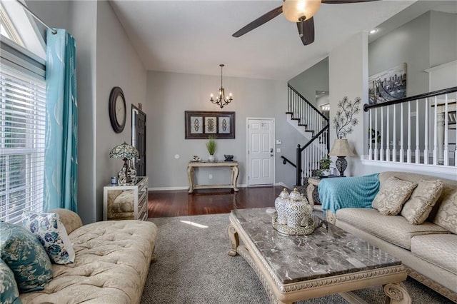 living area featuring a chandelier, stairs, wood finished floors, a ceiling fan, and baseboards