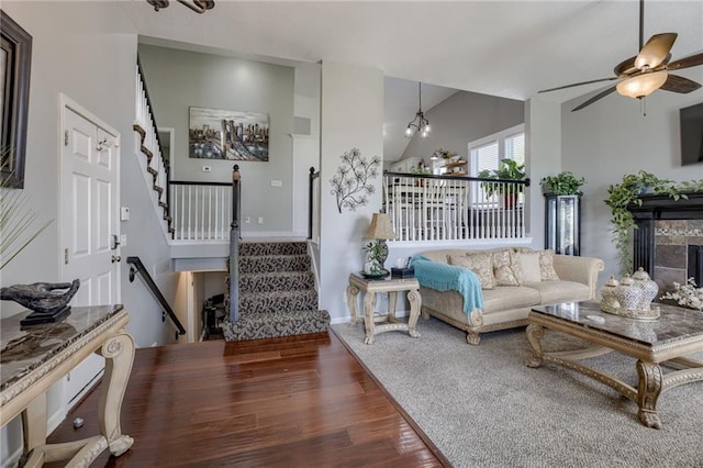 living room with wood finished floors, lofted ceiling, stairway, a ceiling fan, and a fireplace