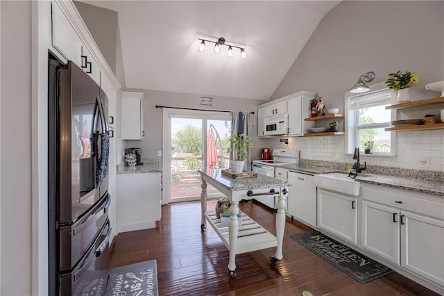 kitchen featuring white appliances, open shelves, a sink, lofted ceiling, and backsplash