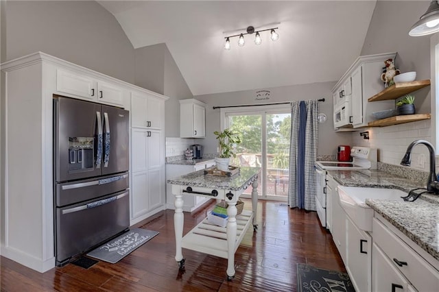 kitchen with white appliances, vaulted ceiling, open shelves, a sink, and white cabinetry