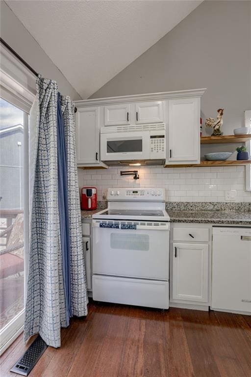 kitchen with white appliances, vaulted ceiling, white cabinets, dark wood-style flooring, and backsplash