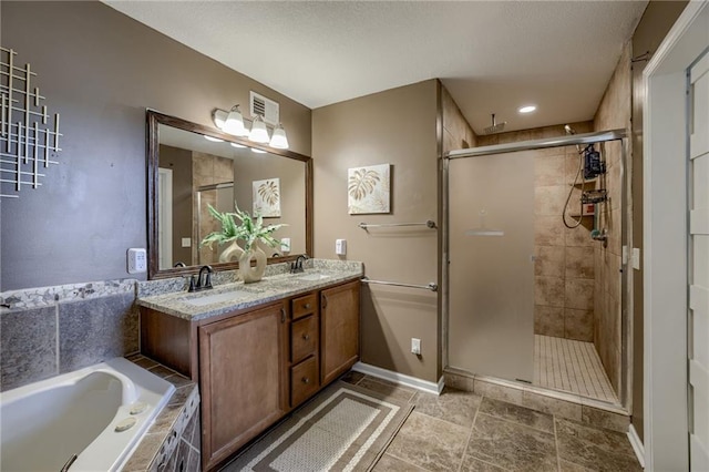 bathroom featuring a shower stall, a garden tub, double vanity, and baseboards