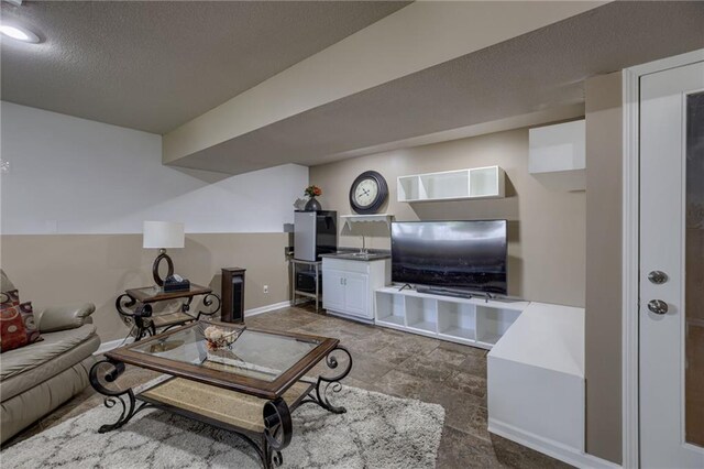 living room featuring baseboards and a textured ceiling