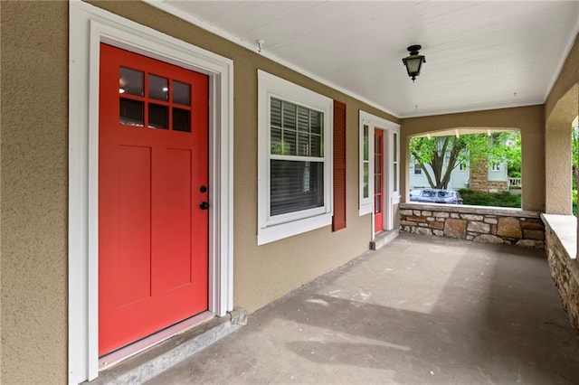 5547 Rockhill Rd, Kansas City, MO 64110 - doorway to property with a porch and stucco siding
