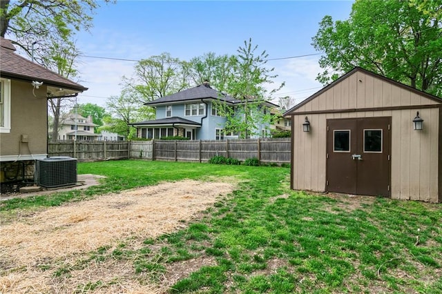 5547 Rockhill Rd, Kansas City, MO 64110 - view of yard featuring a storage shed, an outbuilding, a fenced backyard, and central AC unit
