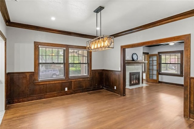 5547 Rockhill Rd, Kansas City, MO 64110 - unfurnished dining area with a chandelier, wood finished floors, ornamental molding, and wainscoting