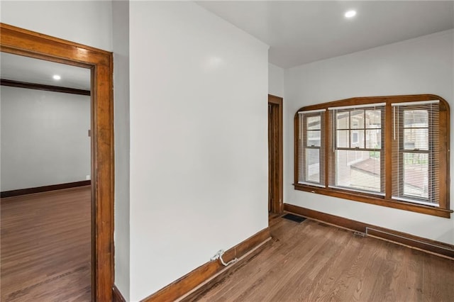5547 Rockhill Rd, Kansas City, MO 64110 - unfurnished room with visible vents, baseboards, wood finished floors, and recessed lighting