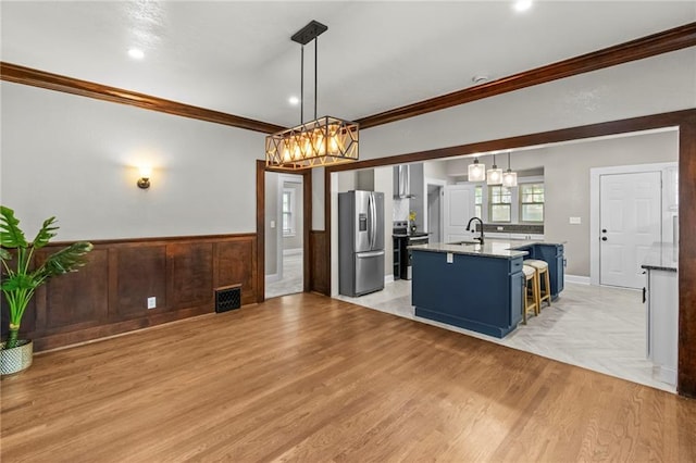 5547 Rockhill Rd, Kansas City, MO 64110 - kitchen featuring blue cabinets, stainless steel appliances, visible vents, and a chandelier