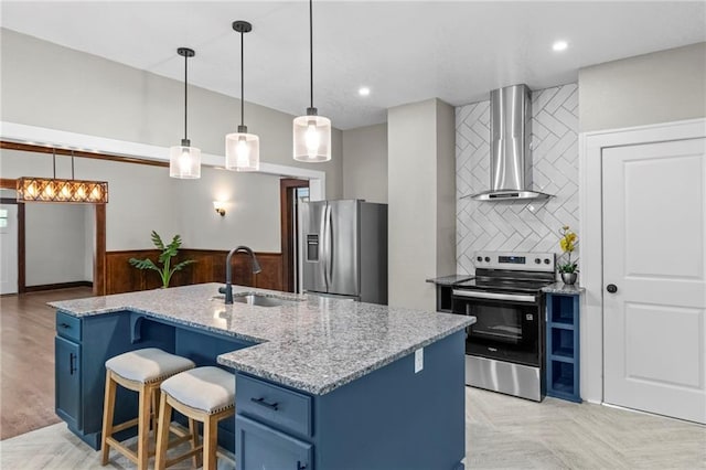 5547 Rockhill Rd, Kansas City, MO 64110 - kitchen featuring a sink, blue cabinets, backsplash, wall chimney exhaust hood, and appliances with stainless steel finishes