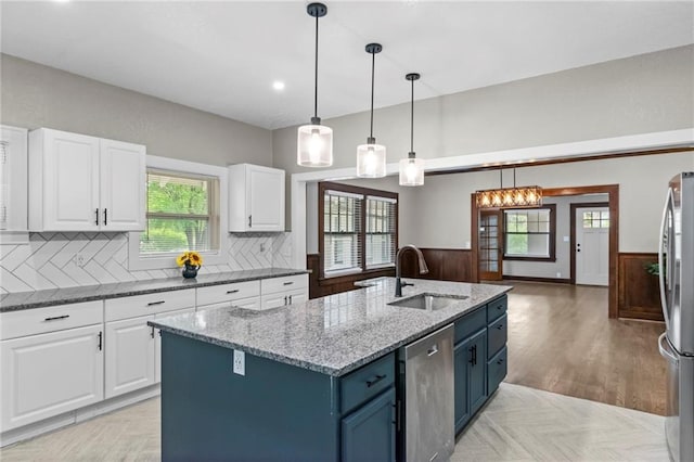 5547 Rockhill Rd, Kansas City, MO 64110 - kitchen featuring appliances with stainless steel finishes, a wainscoted wall, a sink, and white cabinetry