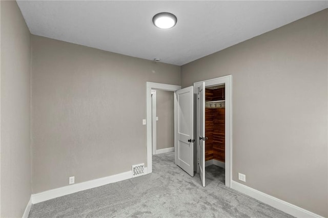 5547 Rockhill Rd, Kansas City, MO 64110 - unfurnished bedroom with a closet, carpet, a spacious closet, and baseboards