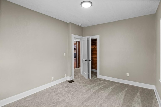 5547 Rockhill Rd, Kansas City, MO 64110 - unfurnished bedroom featuring carpet, visible vents, and baseboards