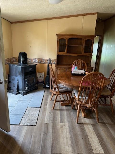 4323 NW County Road 17402nd St, Adrian, MO 64720 - dining area featuring a wood stove, a textured ceiling, and light wood finished floors