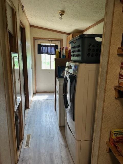 4323 NW County Road 17402nd St, Adrian, MO 64720 - washroom featuring light wood-style flooring, washer and clothes dryer, ornamental molding, and a textured ceiling