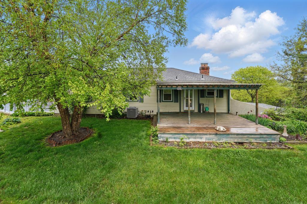 back of house with a yard, central air condition unit, a wooden deck, and a chimney