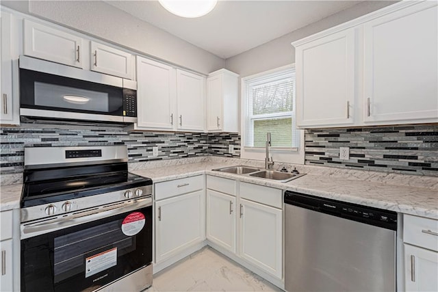 709 W 28th St N, Independence, MO 64050 - kitchen featuring marble finish floor, stainless steel appliances, a sink, decorative backsplash, and white cabinetry