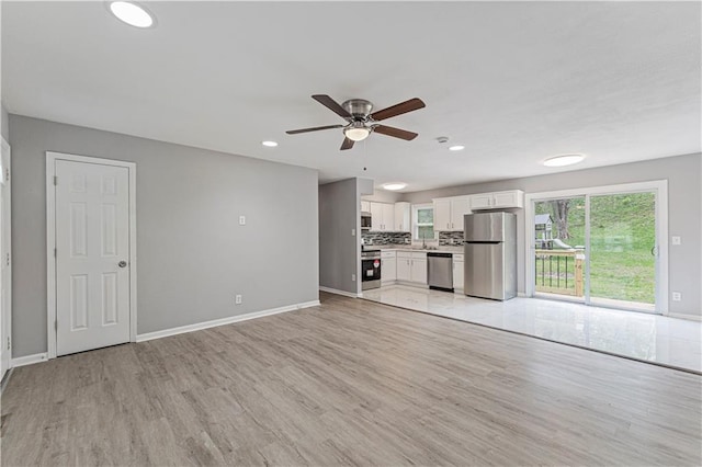709 W 28th St N, Independence, MO 64050 - unfurnished living room with recessed lighting, baseboards, a ceiling fan, and light wood-type flooring