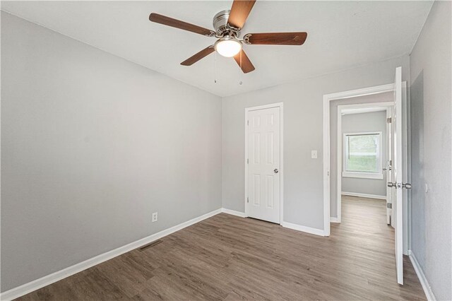 709 W 28th St N, Independence, MO 64050 - unfurnished bedroom with wood finished floors, visible vents, baseboards, and ceiling fan
