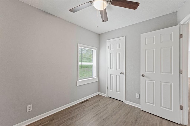 709 W 28th St N, Independence, MO 64050 - unfurnished bedroom featuring baseboards, wood finished floors, visible vents, and ceiling fan