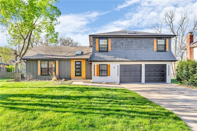 split level home featuring a front yard, driveway, board and batten siding, an attached garage, and fence