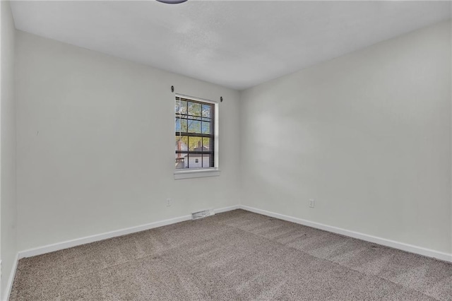 carpeted spare room featuring baseboards