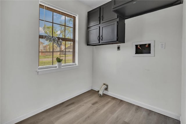 washroom featuring hookup for an electric dryer, light wood finished floors, cabinet space, and baseboards