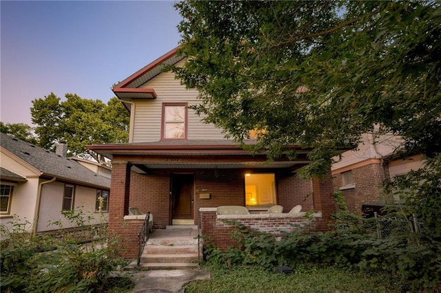 view of front facade with a porch and brick siding