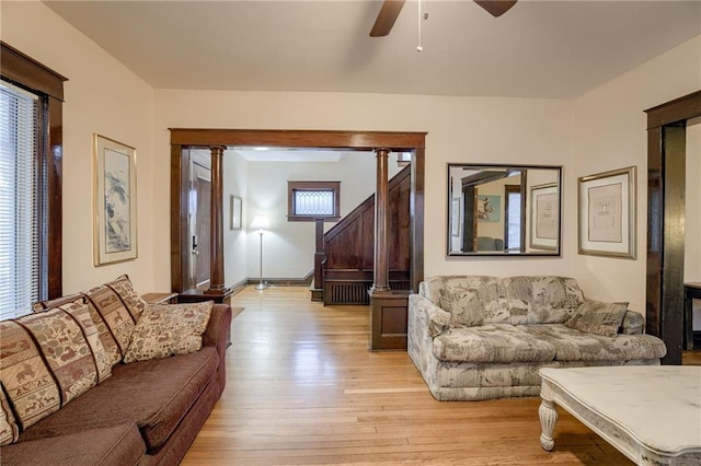 living area featuring baseboards, a ceiling fan, stairs, and light wood-style floors