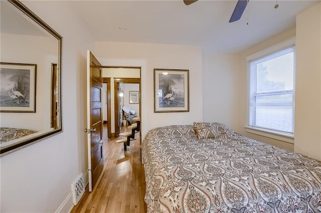 bedroom featuring ceiling fan, light wood-style floors, and visible vents