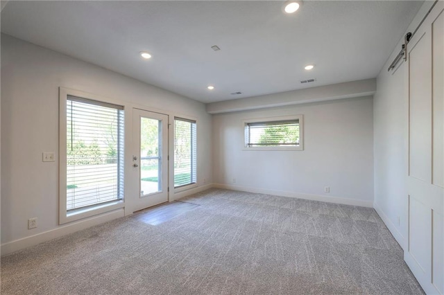 18670 W 248th St, Paola, KS 66071 - unfurnished room featuring light colored carpet, baseboards, a barn door, and recessed lighting