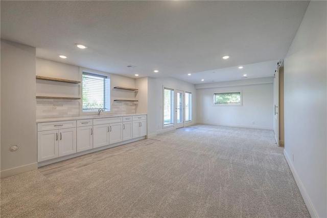 18670 W 248th St, Paola, KS 66071 - unfurnished living room with light colored carpet, baseboards, recessed lighting, and a sink
