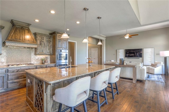 18670 W 248th St, Paola, KS 66071 - kitchen with custom range hood, a sink, light stone countertops, recessed lighting, and backsplash