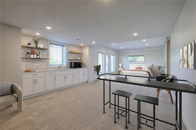 18670 W 248th St, Paola, KS 66071 - kitchen with open shelves, stainless steel microwave, light colored carpet, a sink, and white cabinetry