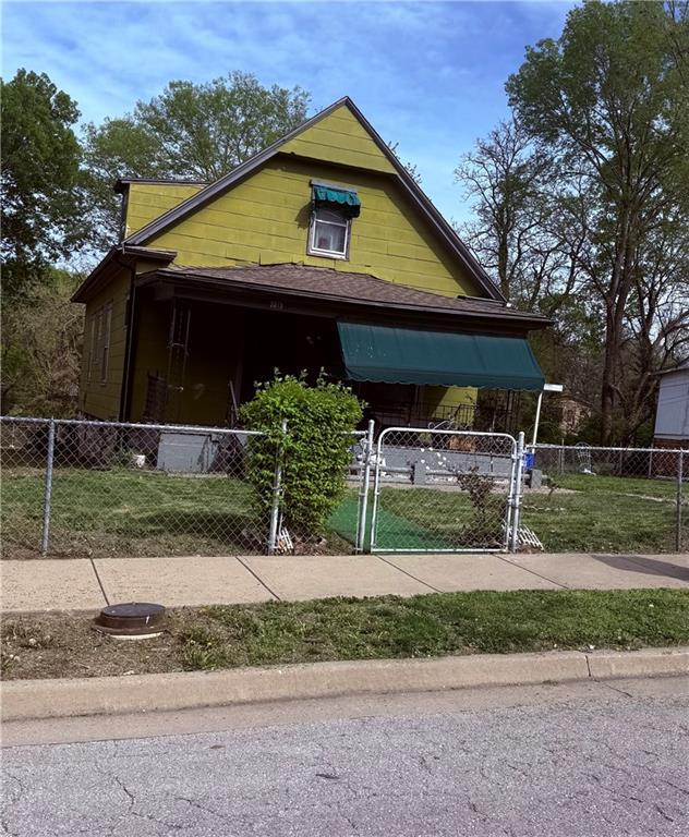 view of front facade with a front lawn, a fenced front yard, and a gate