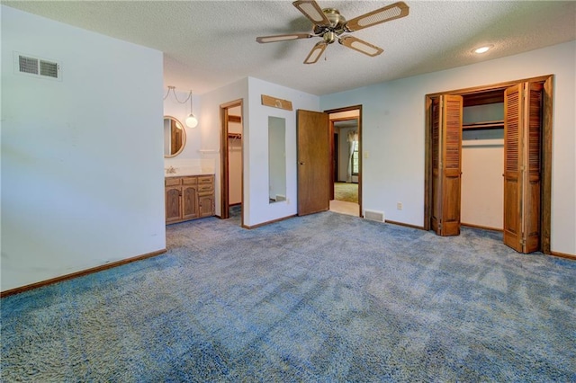 unfurnished bedroom with a textured ceiling, carpet floors, baseboards, and a closet