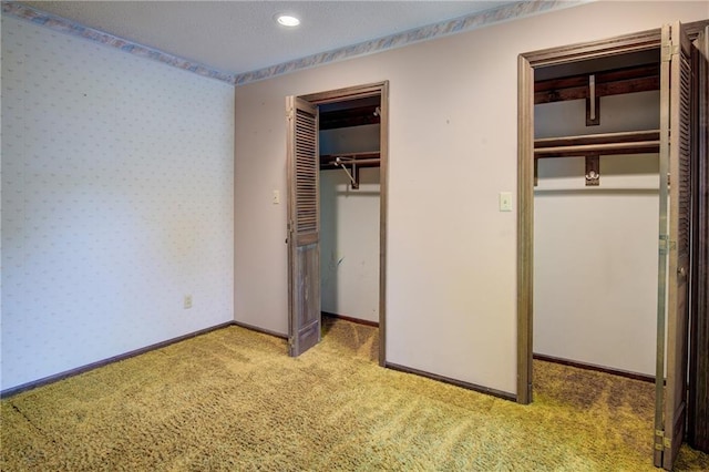 unfurnished bedroom with carpet floors, a closet, recessed lighting, wallpapered walls, and baseboards