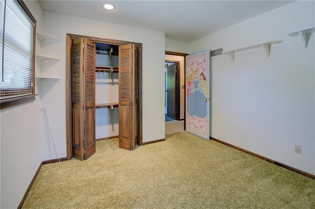 unfurnished bedroom featuring carpet floors, a closet, baseboards, and a textured ceiling