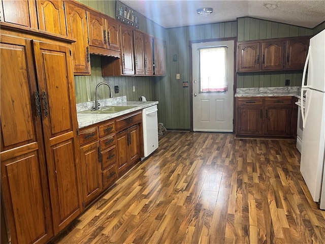 kitchen with dark wood finished floors, a sink, light countertops, lofted ceiling, and white appliances