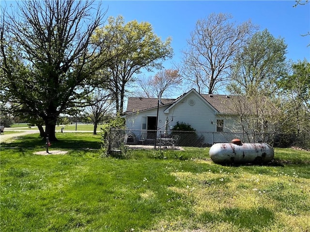 view of side of home with fence and a yard