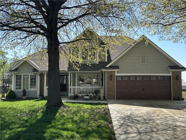 2317 Rhonda Rd, Excelsior Springs, MO 64024 - view of front of house with a porch, brick siding, concrete driveway, and a front lawn