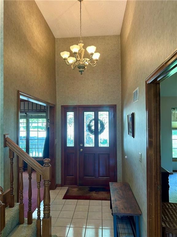 2317 Rhonda Rd, Excelsior Springs, MO 64024 - foyer with a high ceiling, a chandelier, light tile patterned floors, and healthy amount of natural light
