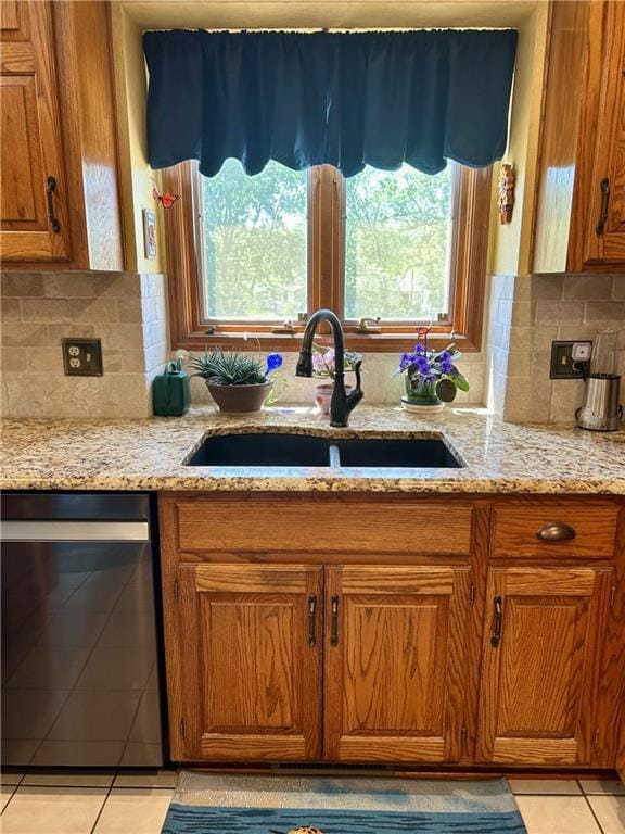 2317 Rhonda Rd, Excelsior Springs, MO 64024 - kitchen with dishwasher, a sink, brown cabinetry, light tile patterned floors, and plenty of natural light