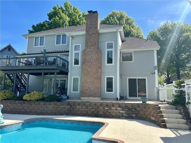 2317 Rhonda Rd, Excelsior Springs, MO 64024 - rear view of house featuring a chimney, a patio, a wooden deck, fence, and an outdoor pool