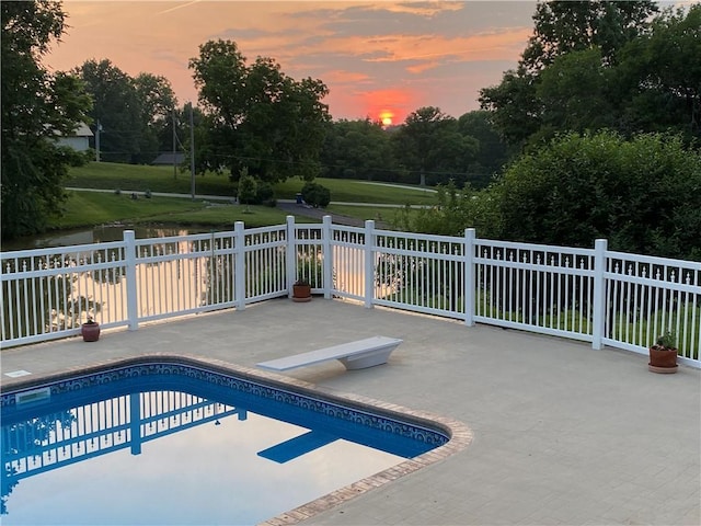 2317 Rhonda Rd, Excelsior Springs, MO 64024 - pool at dusk with a diving board, a patio, fence, and a water view