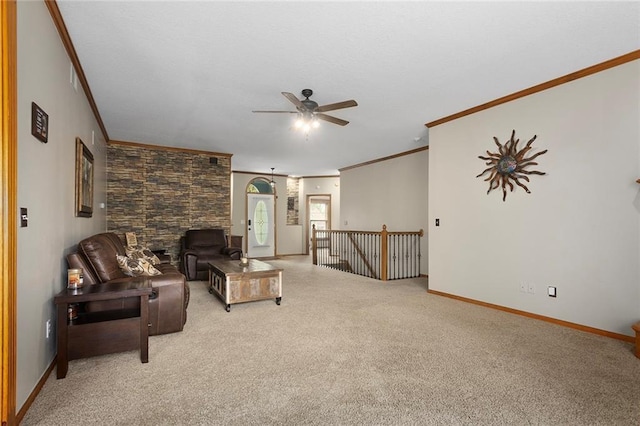 living area with crown molding, baseboards, light carpet, and a ceiling fan