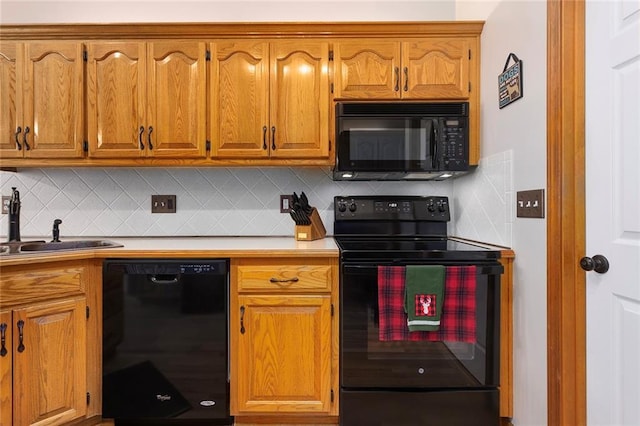 kitchen featuring backsplash, brown cabinets, a sink, and black appliances