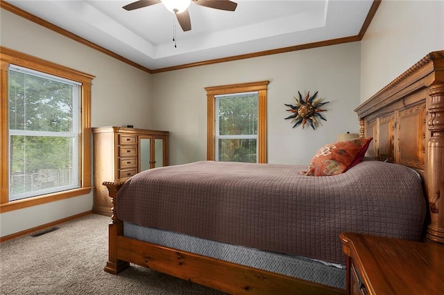 bedroom featuring visible vents, baseboards, ceiling fan, a tray ceiling, and carpet