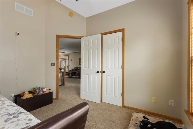 bedroom with baseboards, visible vents, and light carpet