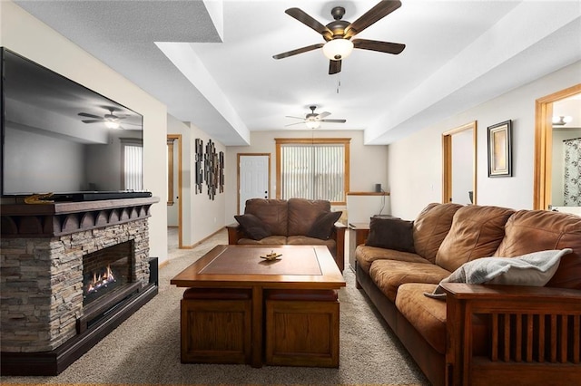 living room featuring carpet, ceiling fan, and a fireplace